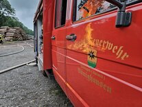 Hier sehen Sie ein Feuerwehrfahrzeug, wo sich das Feuer im Lack spiegelt.
