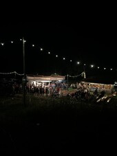 Hier sehen Sie den Festplatz bei dunkelheit in gemütlicher Atmosphere mit Lichterkette und Getränkeständen.