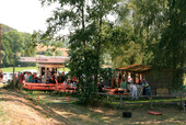 Hier sehen Sie den Festplatz mit Getränke- und Essensstand. Außerdem mit vielen Bänken und Tischen.